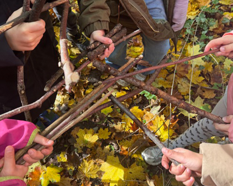 Kinder überkreuzen im Wald Stöcke